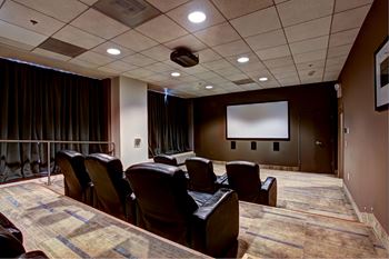 A movie theater with rows of seats and a large screen.